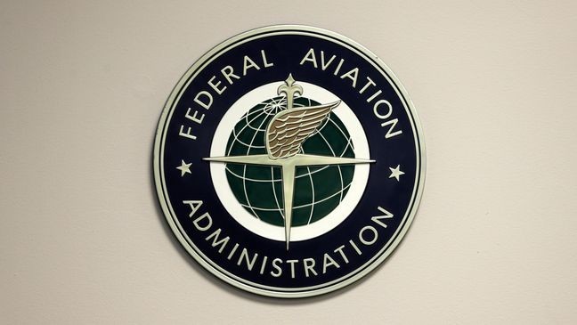 FILE - A Federal Aviation Administration sign hangs in the tower at John F. Kennedy International Airport in New York, March 16, 2017. (AP Photo/Seth Wenig, File)